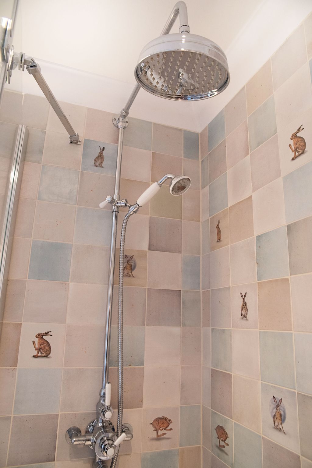 Roper Rhodes Halcyon chrome shower system with rainfall head over bath surrounded by Wiltshire Hares tiles Coggeshall CO6