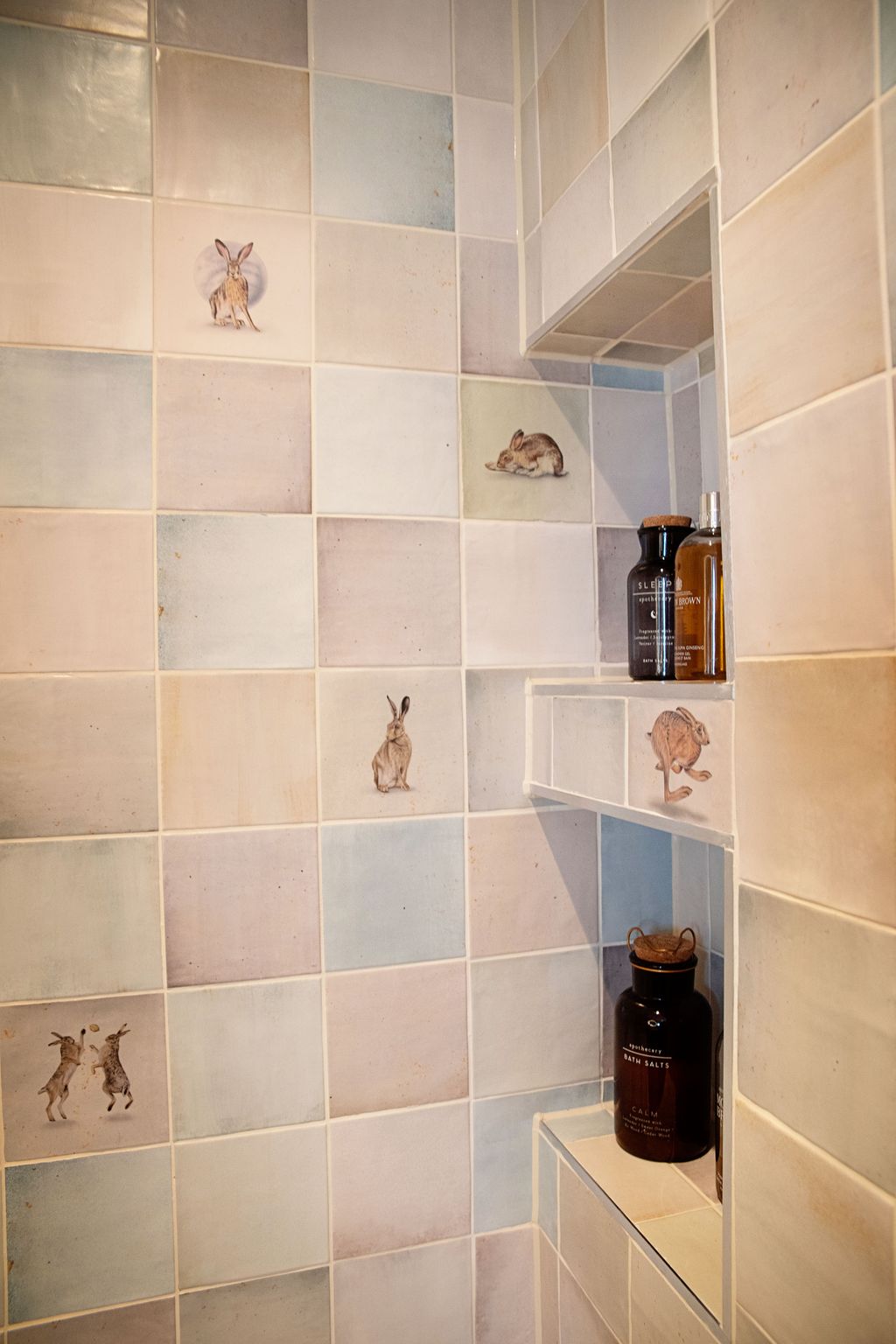 Stacked shower niches with Wiltshire Hares tiles holding bottles and bath salts Coggeshall CO6