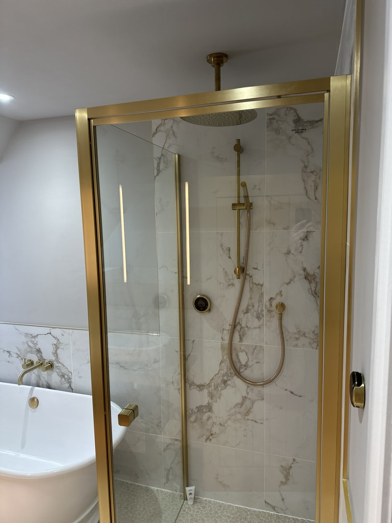 Brushed brass shower enclosure with ceiling rainfall head and Elisa smart control in a Colchester CO1 family bathroom