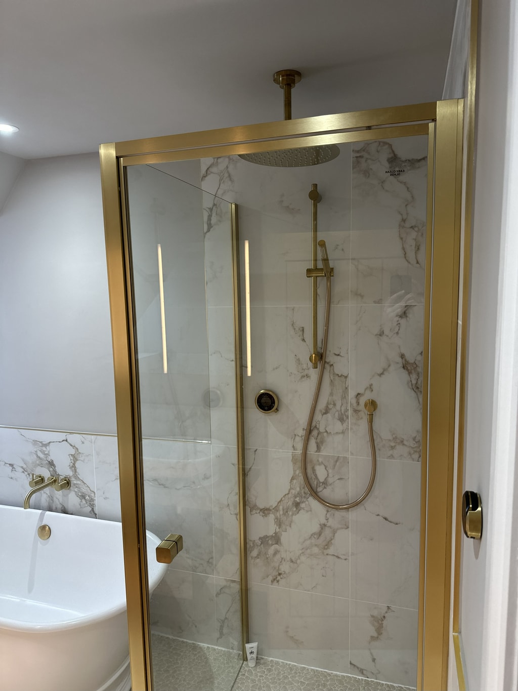 Brushed brass shower enclosure with ceiling rainfall head hand shower and Elisa smart control Colchester CO1
