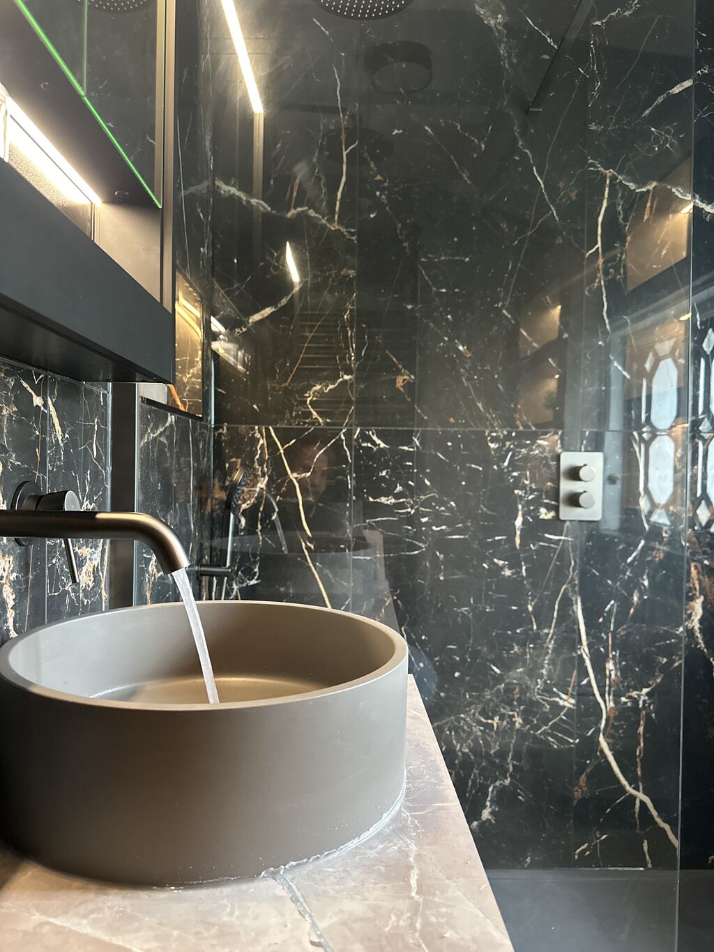Concrete-grey vessel basin with fluted gunmetal wall-mounted tap running Gosfield CO9 Essex