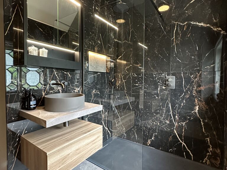 Gosfield CO9 luxury shower room in black marble-effect porcelain with backlit niches