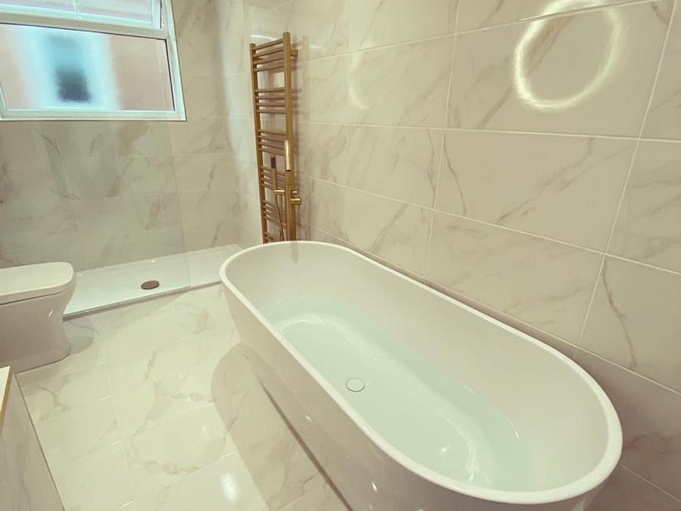 Freestanding bath with brushed brass radiator Porcelanosa marble-effect tiles Great Baddow CM2
