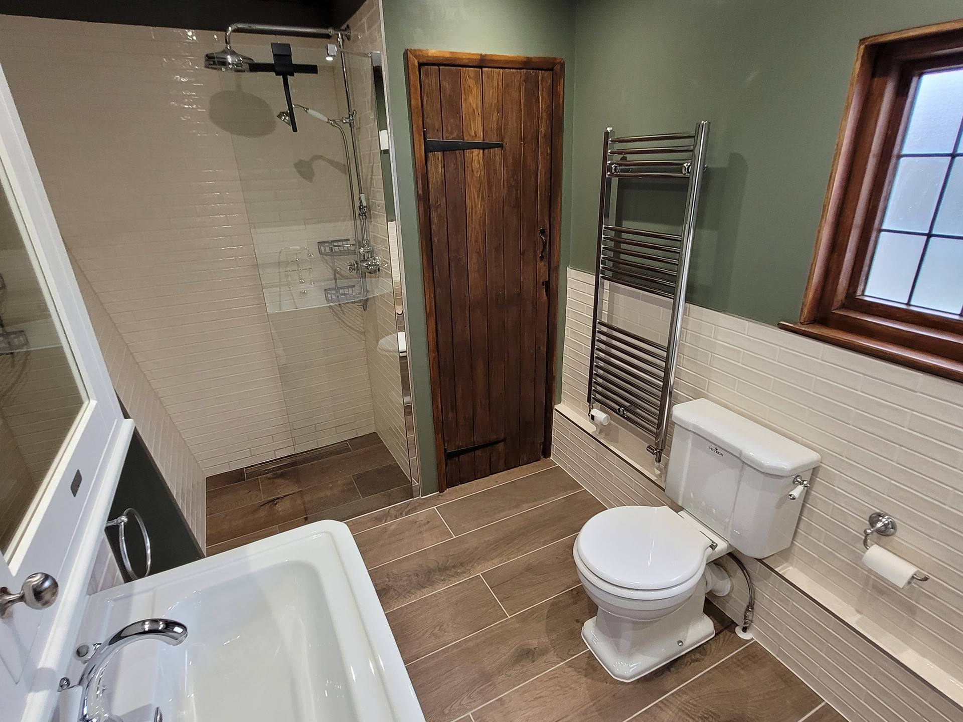 Shower zone with glass screen rustic door WC and chrome radiator Great Bardfield CM6