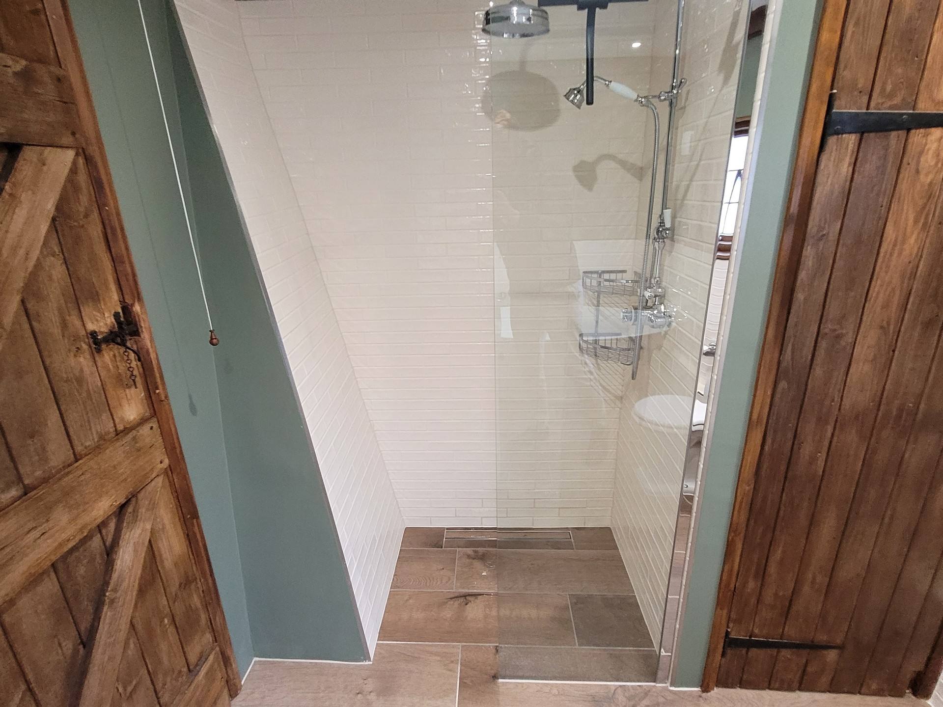 Wetroom shower zone through rustic oak doors chrome rainfall head Great Bardfield CM6