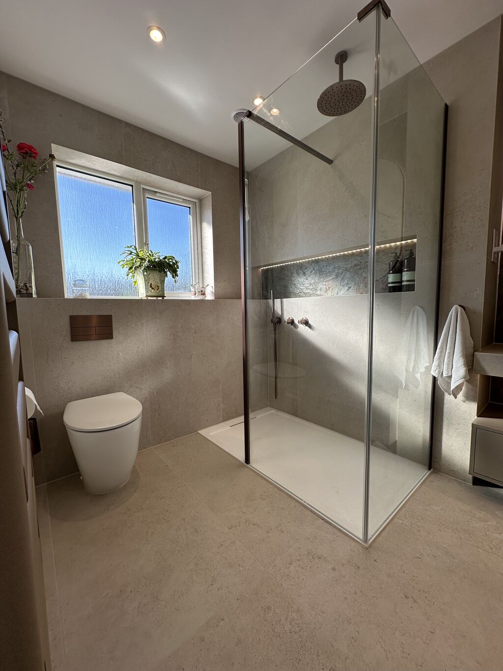 Light-filled walk-in shower with obscured window and wall-hung WC Great Notley CM77 Essex Bowman Bathrooms