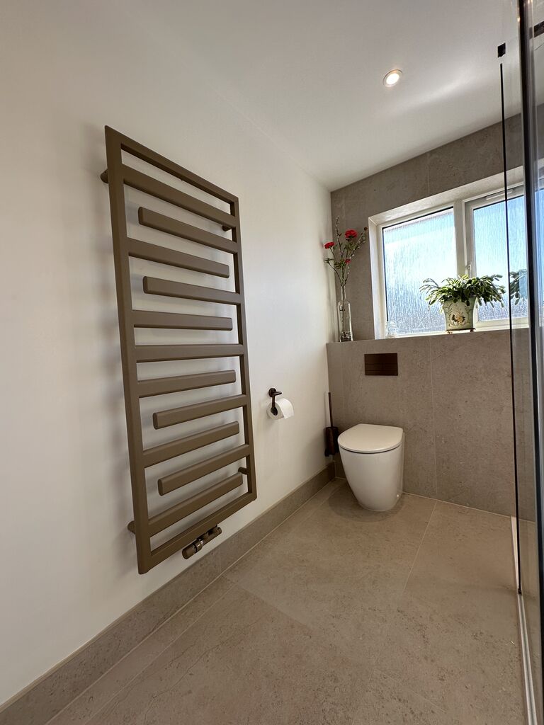 Bronze Zehnder designer towel radiator beside wall-hung WC Great Notley CM77 Essex Bowman Bathrooms