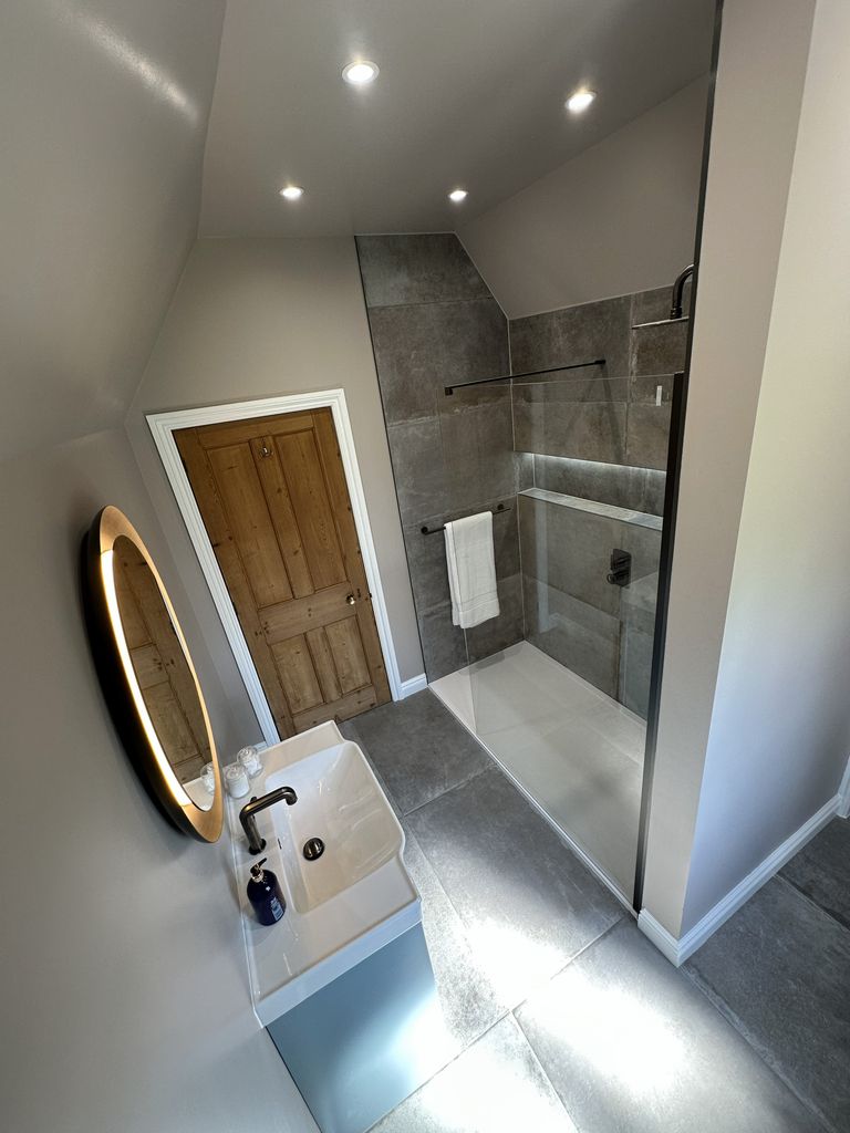 Overhead room view showing Ca' Pietra Cenere floor tiles, Warmup underfloor heating, vanity, heritage door and Gallery 8 shower Great Saling CM7