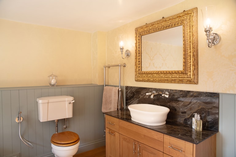 WC, chrome towel rail, vessel basin on granite with gold ornate mirror and Burlington wall lights Halstead CO9