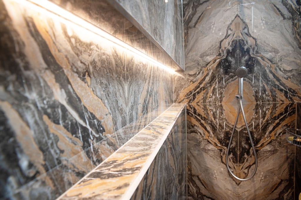 Infinity niche with IP67 recessed LED lighting and Ca' Pietra Nero bookmatched tiles Halstead CO9