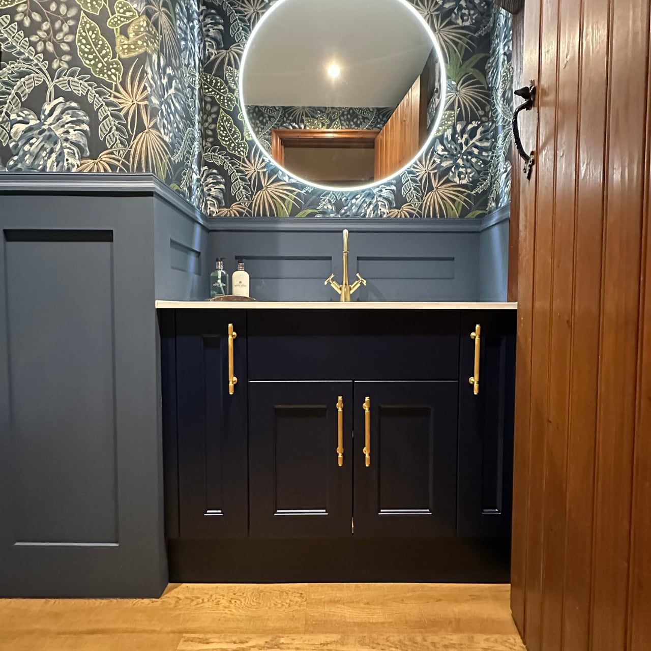 Navy Calypso vanity and HiB Air Round mirror framed by original wooden doorway Hatfield Peverel CM3 cloakroom
