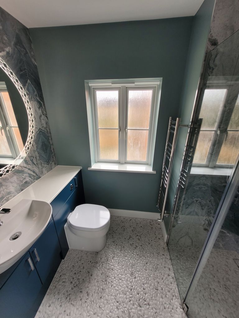 Full room overview with blue vanity, HiB Bellus mirror, and wetroom shower zone Highwoods CO4 Bowmans
