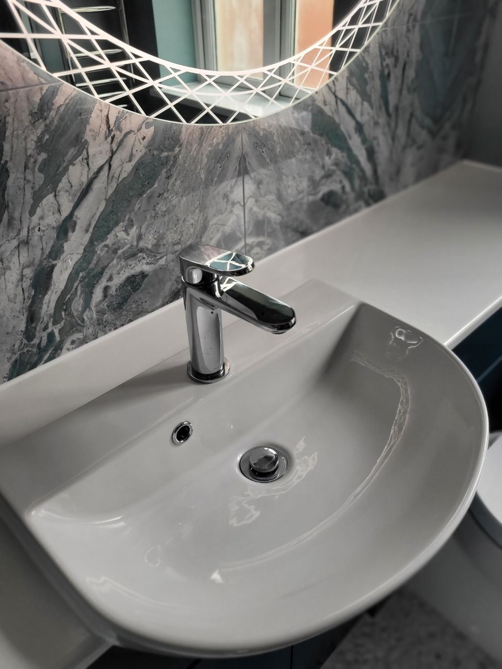 Chrome basin mixer close-up on white semi-recessed basin with Ocean Magnifique slab and HiB Bellus mirror Highwoods CO4