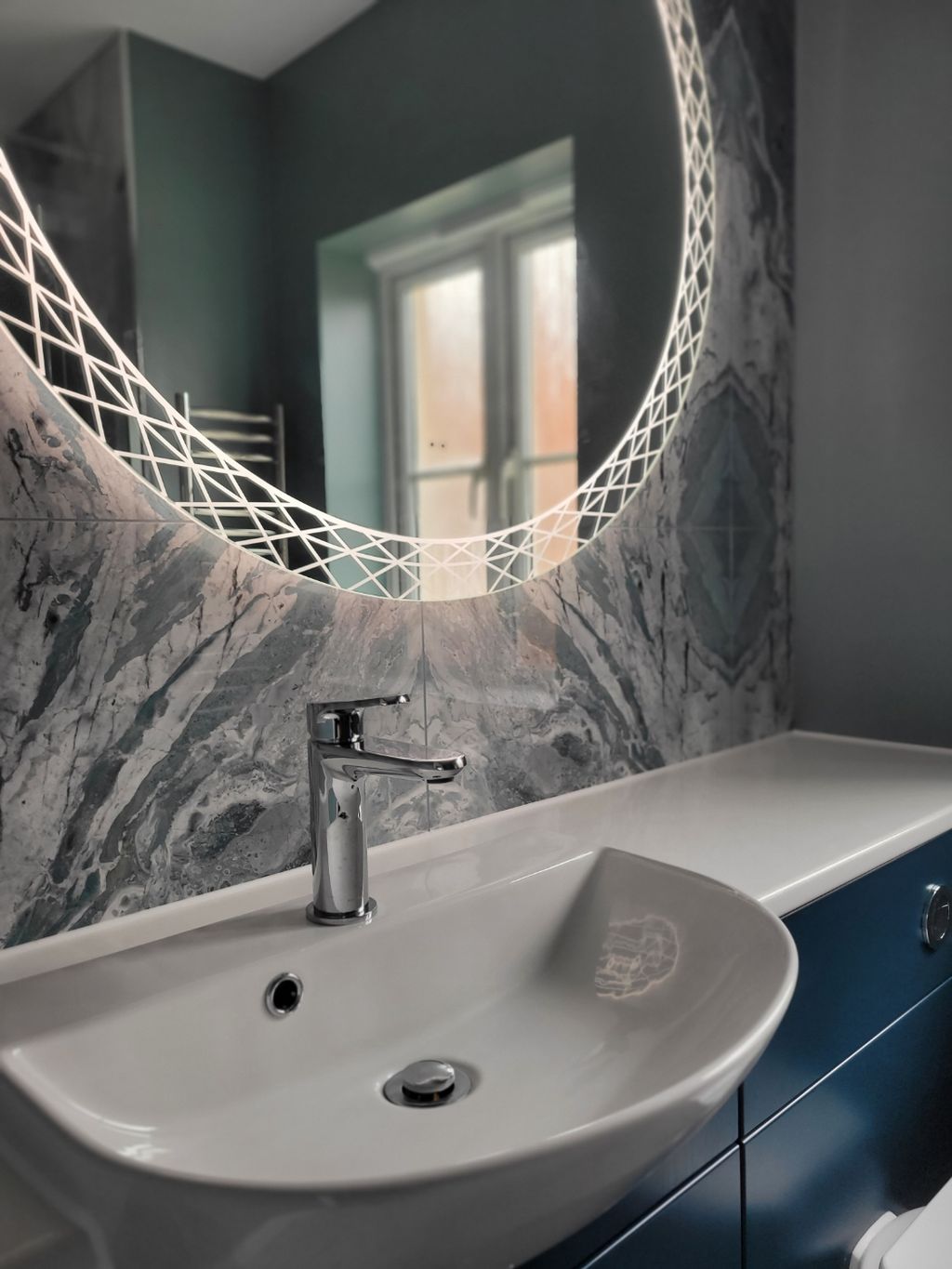 HiB Bellus mirror crosshatch LED rim close-up with Ocean Magnifique slabs and chrome basin mixer Highwoods CO4