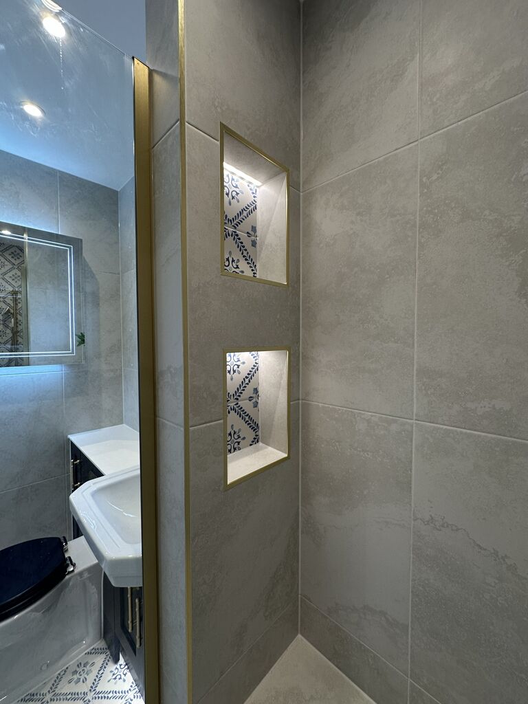View from the walk-in shower across navy fitted furniture and patterned floor tiles Kelvedon CO5 Essex