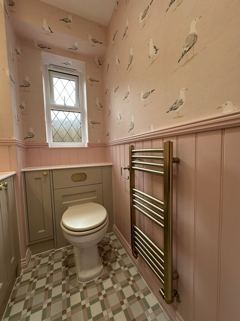 Traditional WC beside a brushed brass ladder towel rail and patterned floor tiles Kelvedon CO5 Essex