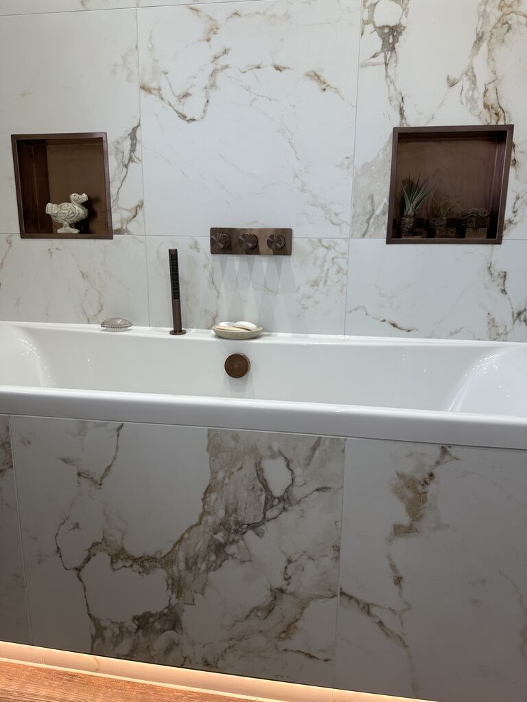 Bath with bronze filler below marble wall niches Kelvedon CO5 Essex Bowman Bathrooms