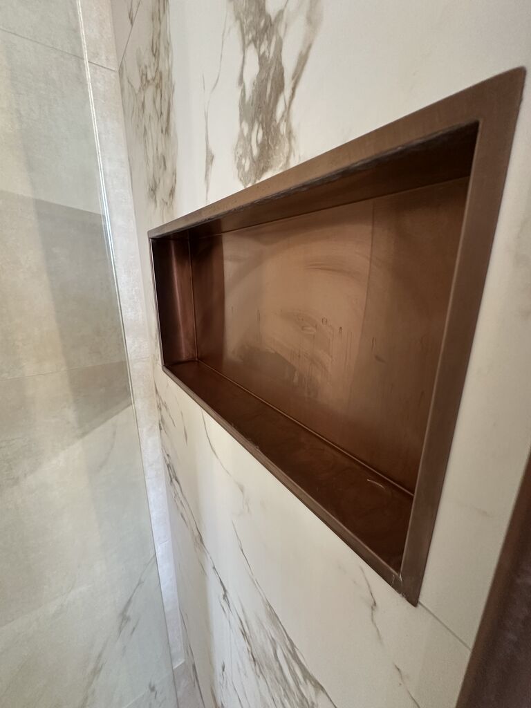 Bronze-lined recessed shower niche in calacatta marble-look porcelain Kelvedon CO5 Essex