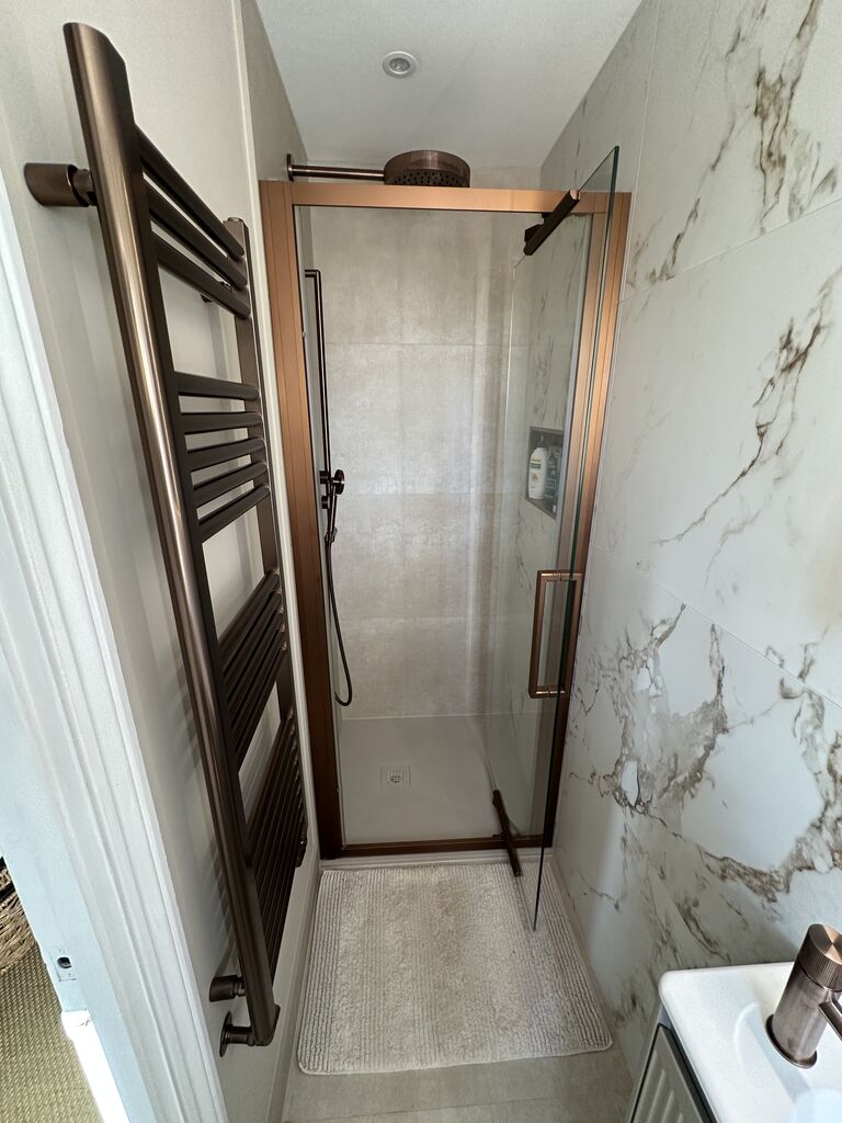 Bronze ladder towel rail beside marble-walled shower Kelvedon CO5 Essex ensuite
