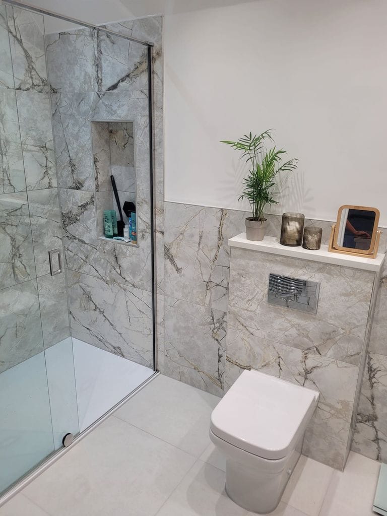 Shower zone with glass screen recessed niche and Burlington globe wall light beside WC Tiptree CO5 Essex