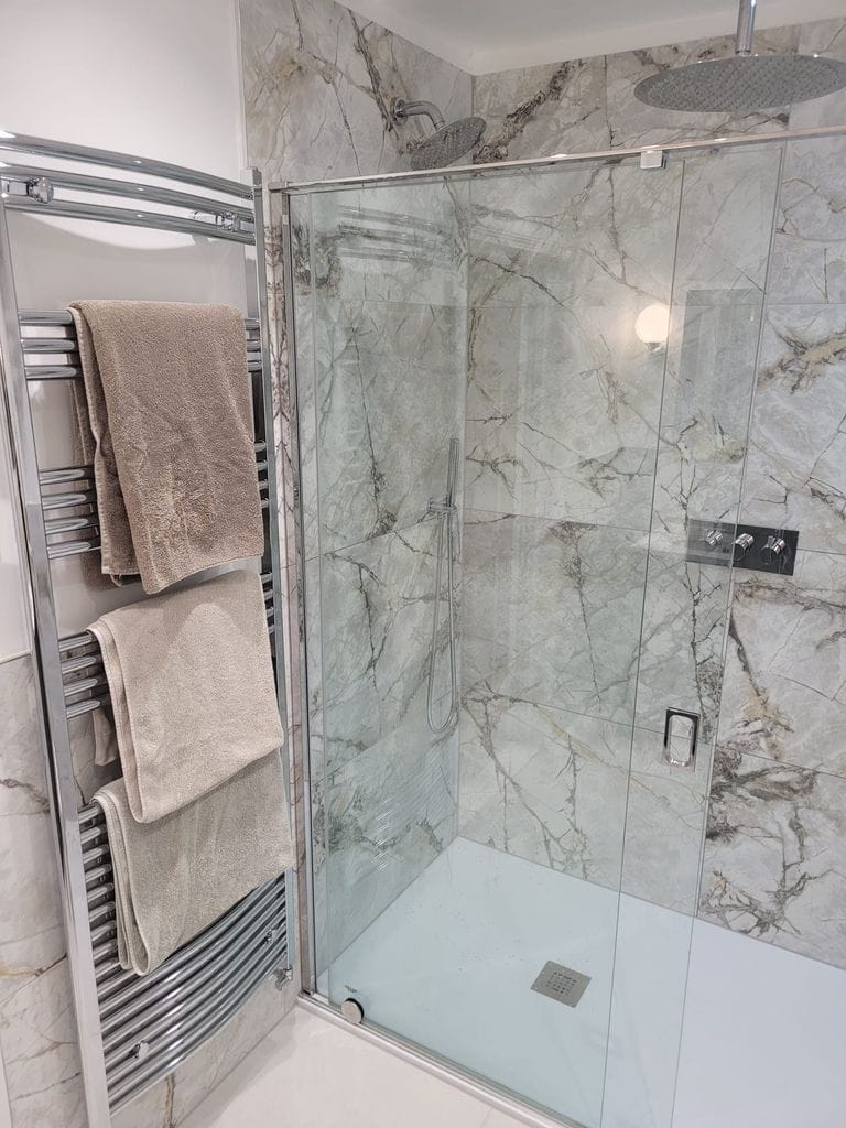 Walk-in shower with Ca' Pietra marble tiles ceiling rain head and chrome heated towel rail Tiptree CO5 Essex