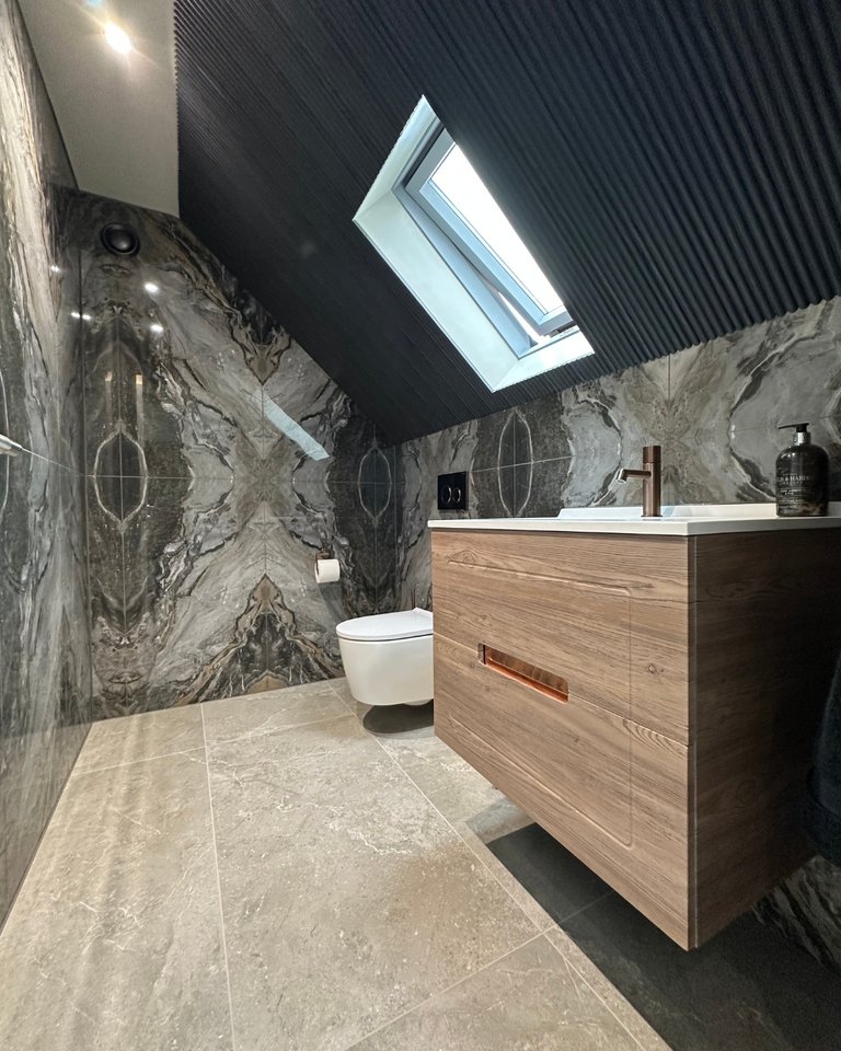 Adjoining WC with Ambiance Bain floating vanity Geberit wall-hung WC bookmatched tiles and skylight West Mersea CO5