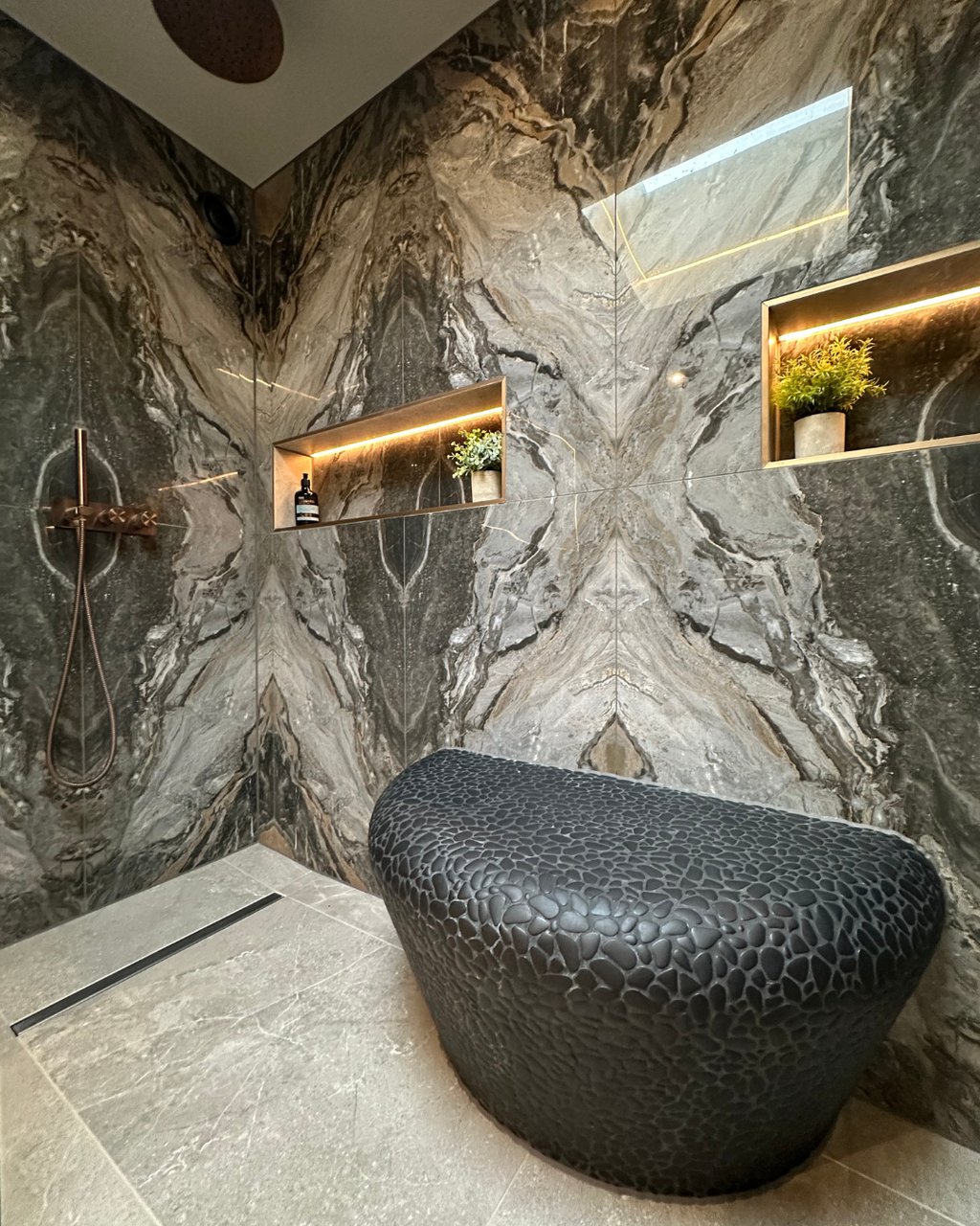 Porcelanosa Boulder Black pebble bench with heated seat between dual showers bookmatched tiles West Mersea CO5