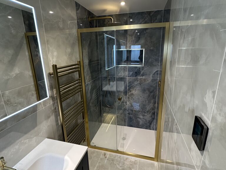 Wickham Bishops CM8 master ensuite with brushed brass enclosure and navy fitted furniture